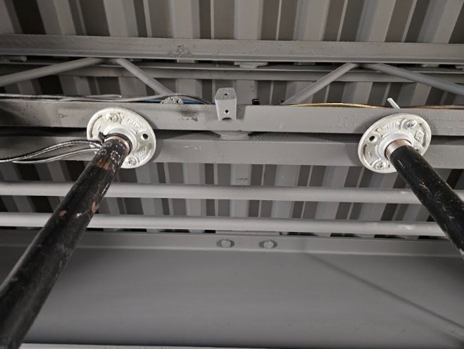 A metal frame with black pipes

AI-generated content may be incorrect.